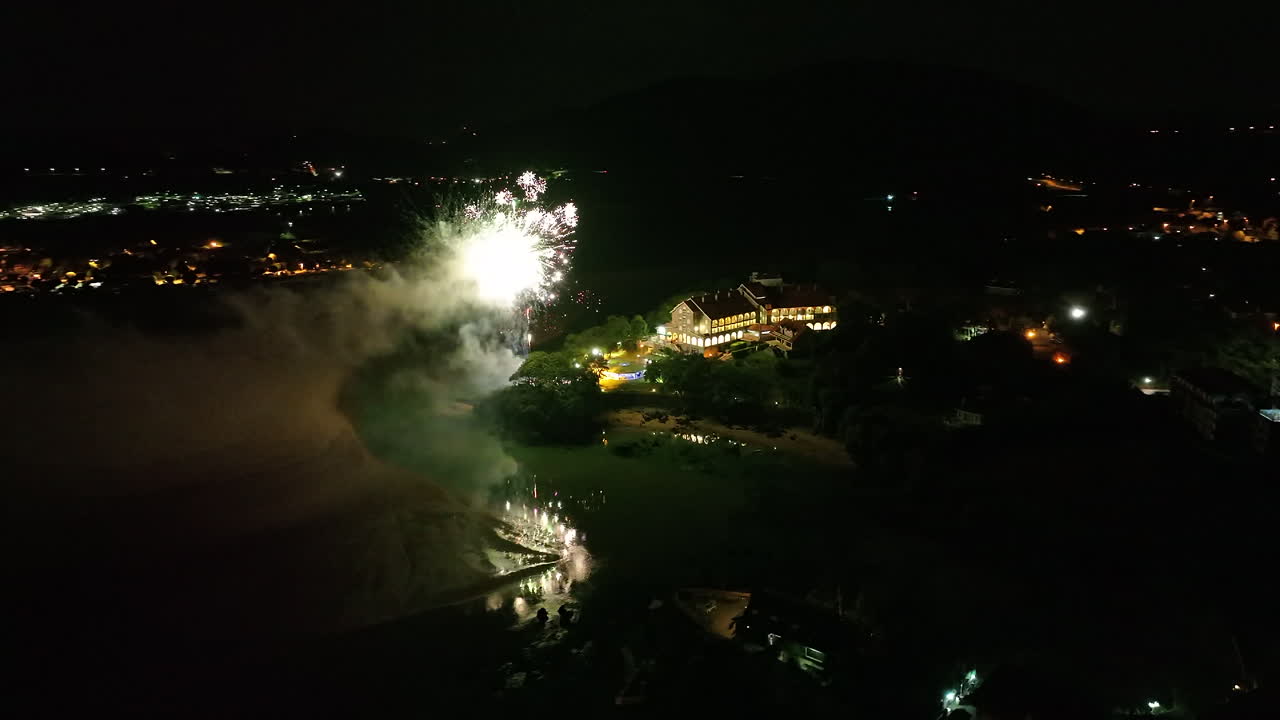 toma aérea de drones de una espectacular exhibición pirotécnica en una playa, fuegos artificiales explotando iluminando el cielo nocturno con hermosos colores, cantabria, españa