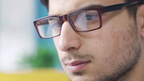 retrato en primer plano de un joven serio y enfocado con gafas.