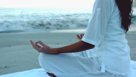 Mujer-Relajándose-En-La-Playa-Practicando-Yoga.-