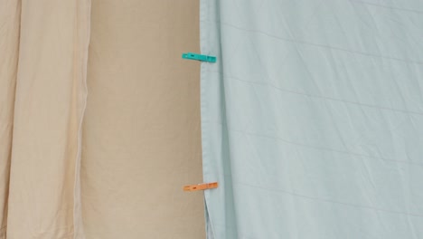 colorful clothespins on a laundry line with sheets in a simple setting