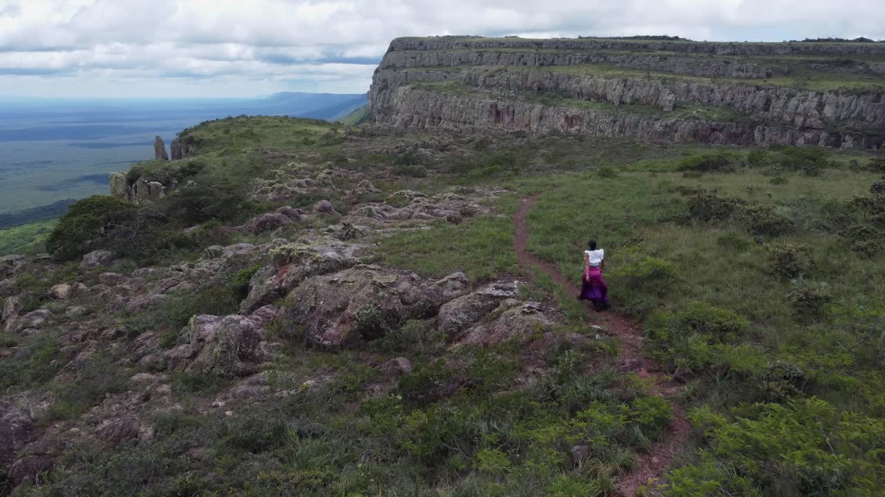 latina camina en el sendero encima de la antecámara del cielo escarpa en bolivia
