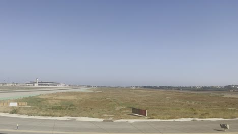 Start-Und-Landebahn-In-Malaga-Mit-Flughafen-Und-Tower-In-Der-Ferne-Der-Landebahn-Mit-Blauem-Himmel