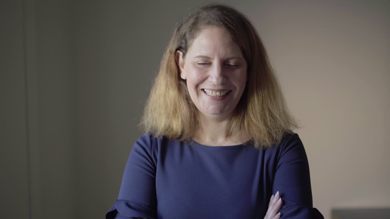 Indoor closeup of positive, smiling middle aged Caucasian woman