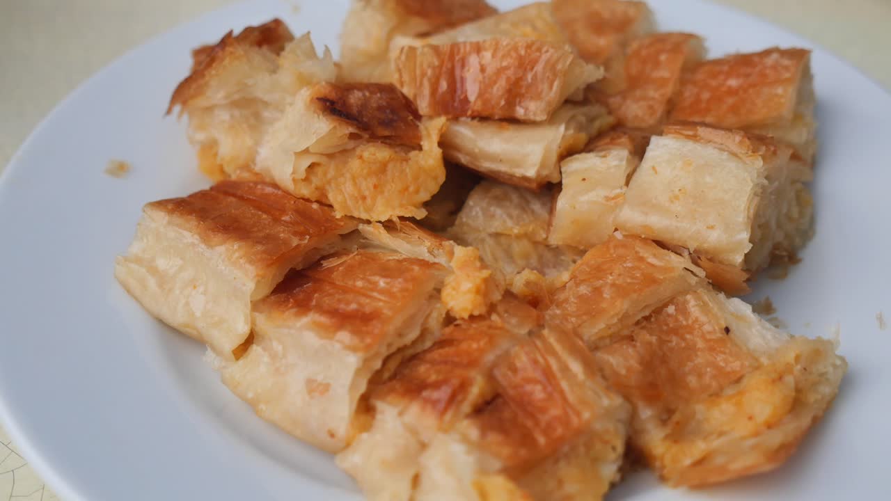Mangiare un Borek salato sfogliato con una forchetta