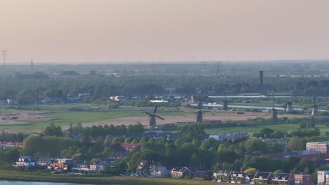 toma panorámica de un molino de viento giratorio en kinderdijk iluminado por el sol poniente