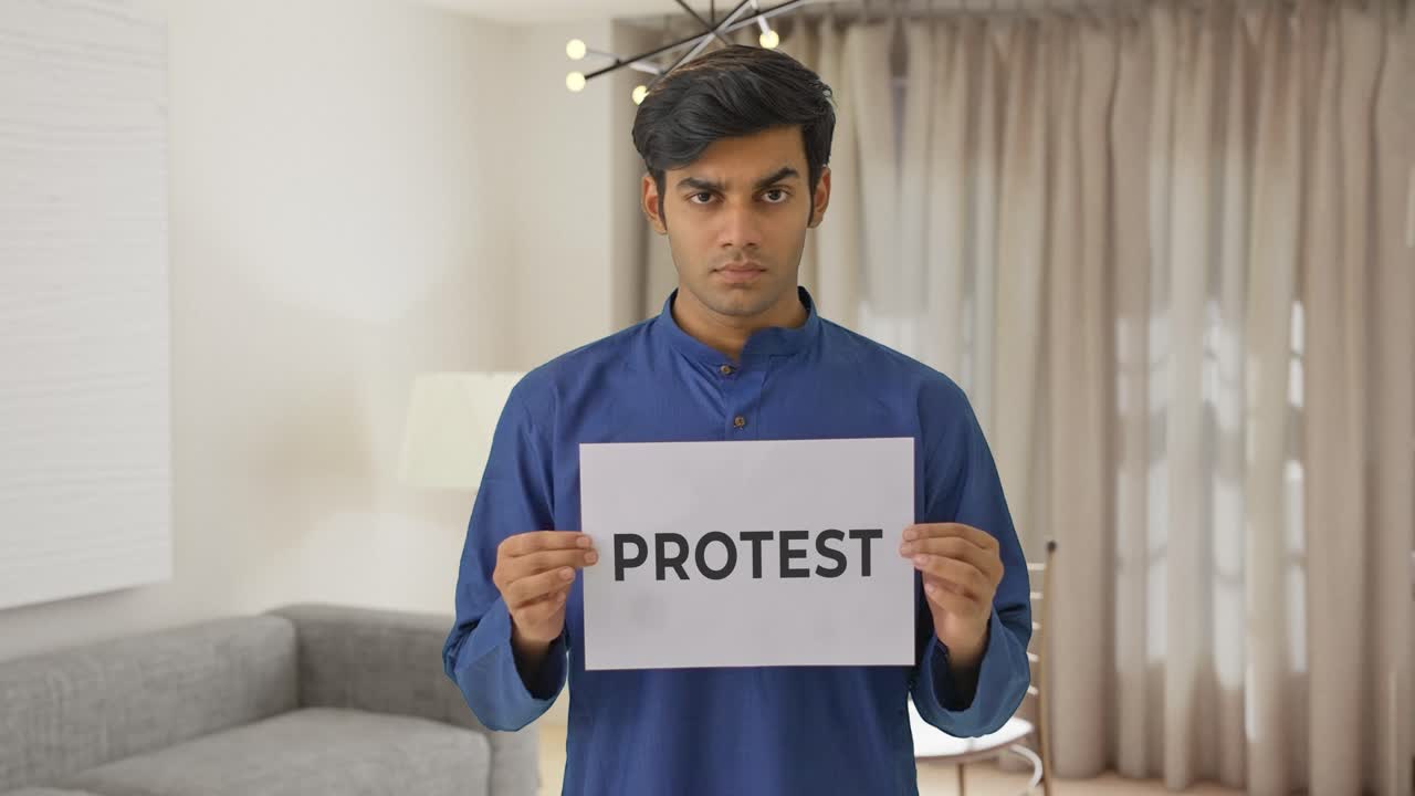 Angry Indian boy holding PROTEST banner