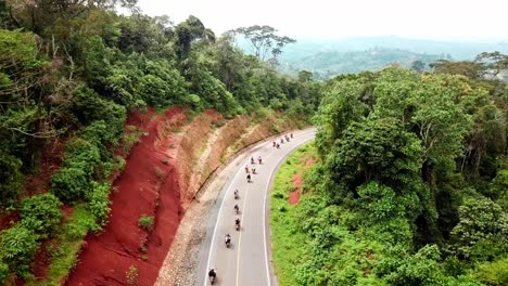 travelers riding motorcycles during safari tour in kenya - aerial drone shot