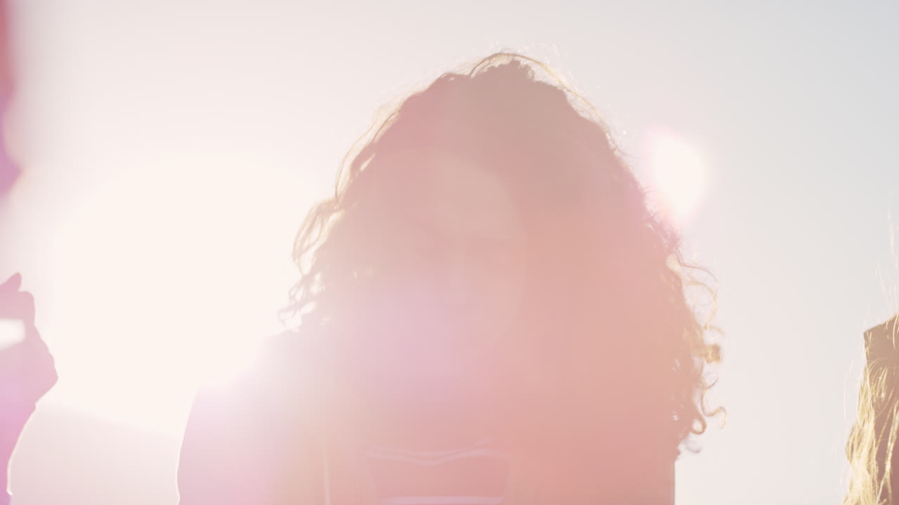 백인 남자가 춤을 추고 다양한 친구들의 그룹이 함께 어울려서 지붕 파티 춤 음악을 즐기고 해가 지면 술을 마시고 주말 모임을 즐기고 있습니다.