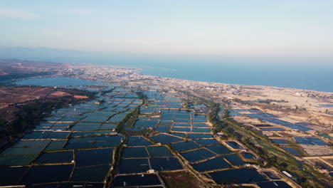 Vista-Aérea-De-Los-Campos-De-Cultivo-De-Camarones-En-Son-Hai-Durante-El-Día-Soleado-Y-La-Hermosa-Costa-En-Vietnam