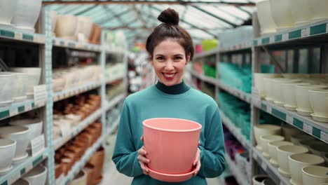 Portrait-of-a-female-customer-chose-clay-flower-pot-for-home-garden-standing-in-floral-department