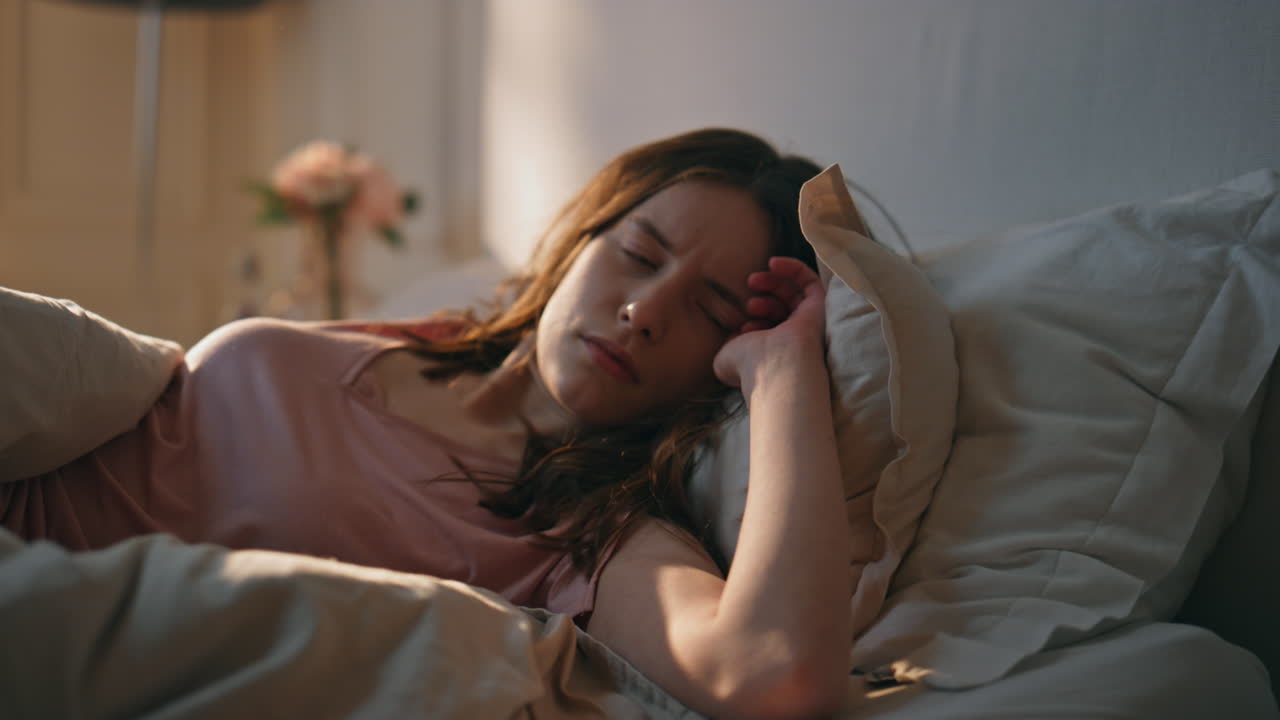 en primer plano, una mujer conmocionada se despierta por la mañana. una chica estresada duerme demasiado.