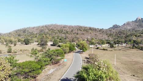 Aerial-shot-of-beautiful-village-and-a-concrete-road-passing-from-the-middle-of-the-village-in-Charu,-Chatra,-Jharkhand,-India