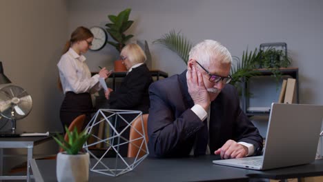 hombre de negocios pensativo usando una computadora portátil se sienta en el escritorio de la oficina, señalando con el dedo en el signo eureka