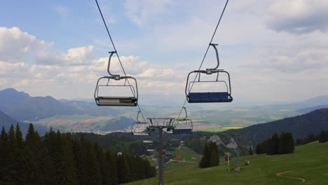 malino brdo resort, ružomberok, liptov, slovakia - empty ski chairlift cable over lush green hills and meadows in summer