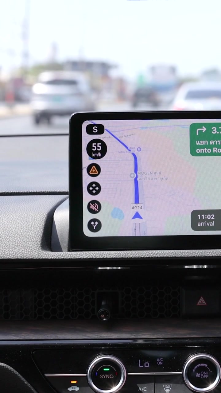 Inquadratura verticale ravvicinata del display di navigazione digitale di un'auto moderna mentre si guida di giorno.