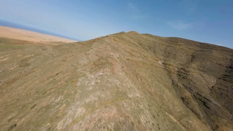 Fuerteventura-Fpv-Trockener-Felsiger-Vulkan-Bergrücken-Klettern-Blauer-Himmel