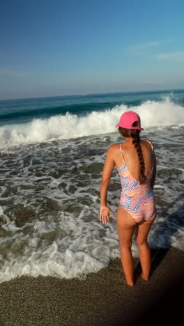 girl at the beach watching the waves