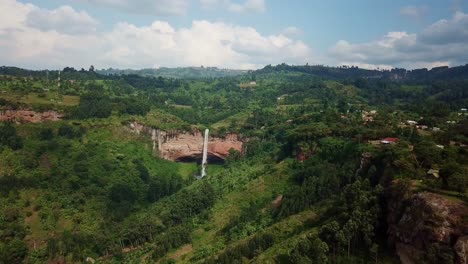 Drone captures scenic view of Sipi Falls plunging down a lush escarpment on Mount Elgon’s verdant slopes in Kapchorwa, Uganda, under partly cloudy skies during the wet season