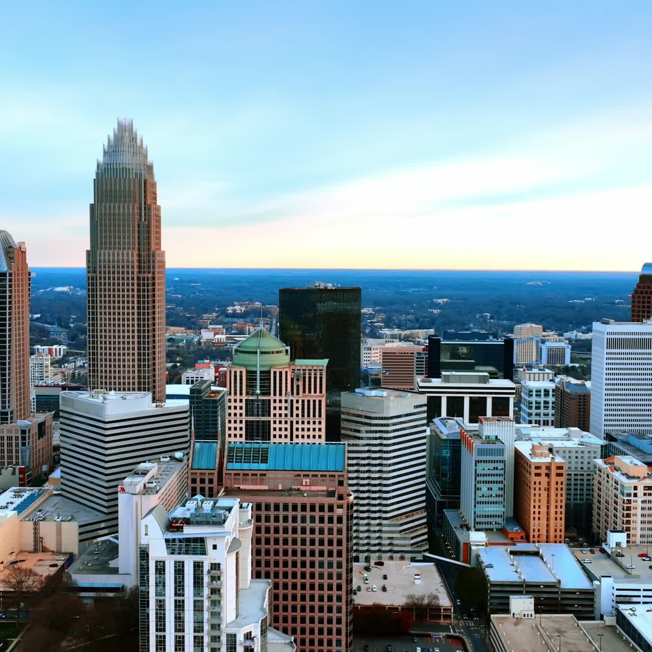 Vackra innerstaden i Charlotte, North Carolina, USA. Drönare som stiger upp längs de moderna skyskraporna mot en bakgrund av blå himmel.