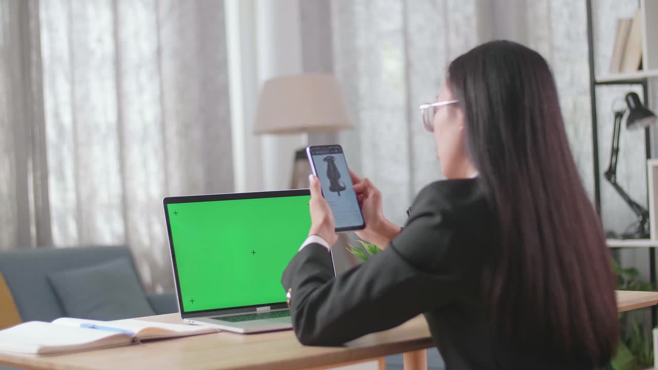 노트북과 스마트폰을 사용하여 집에서 일하는 여성