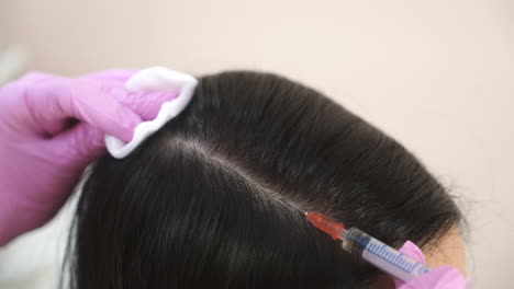 handsome woman receives an injection in the head. the concept of mesotherapy. thrust to strengthen the hair and their growth
