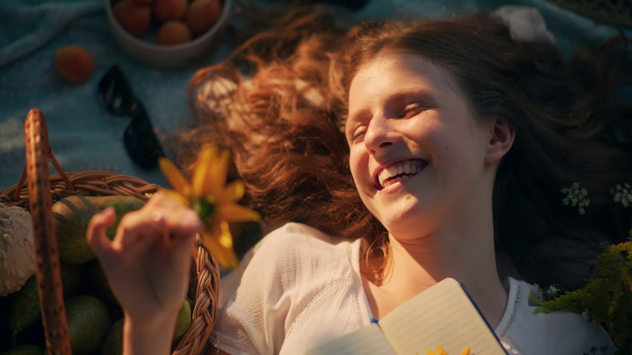 Little girl daydreaming on a blanket in meadow