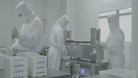 medical worker in protective suits, gear developing new drugs or new vaccine medicines at modern laboratory cleanroom environmental facility setting