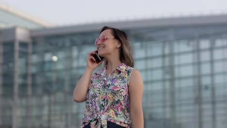 chica con gafas de sol de moda usa su teléfono. usando teléfono inteligente para llamar, hablar. vacaciones, turismo