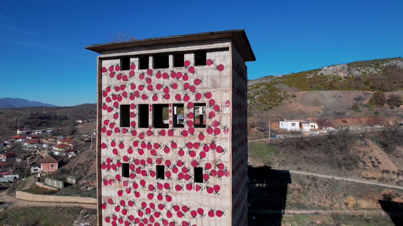torre de fábrica destruida utilizada para el arte, pintada con bichos leddy en albania