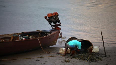 un hombre local soldando y arreglando su bote de cola larga a lo largo del río pak nam en krabi, tailandia