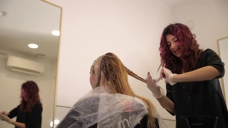 a skilled hair stylist is crafting a stunning transformation for a client in a chic salon, ensuring perfection