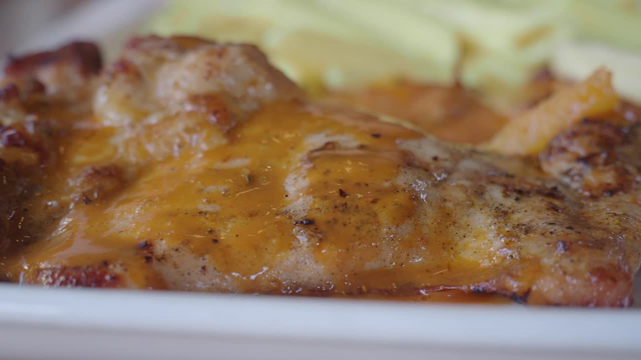 primer plano de un muslo de pollo a la parrilla con salsa