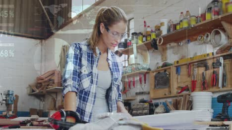 animation of data processing over caucasian female carpenter working in workshop