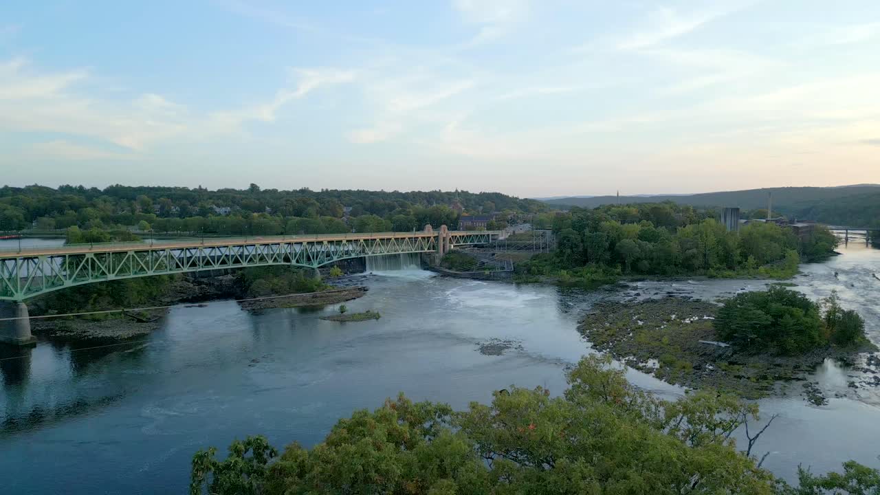 Smooth downward drone fly to the Connecticut River on countryside beneath Turners Falls-Gill Bridge with forest surroundings, Montague, Massachusetts, USA