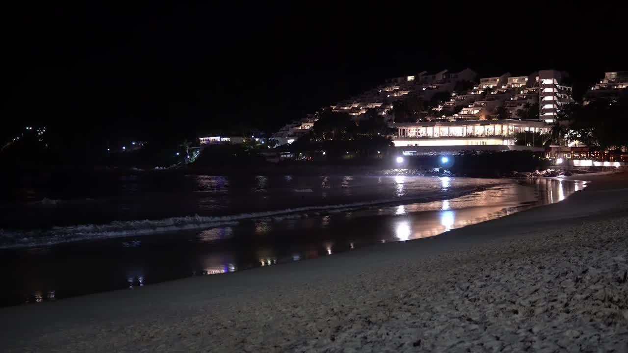 lugar turístico. playa nocturna con vistas a las luces de la ciudad