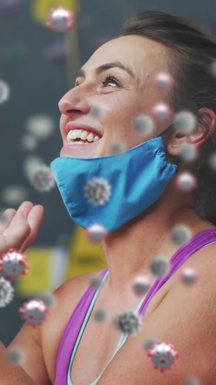 múltiples células de covid-19 flotando contra la mujer en forma caucásica hablando en teléfono inteligente en el gimnasio