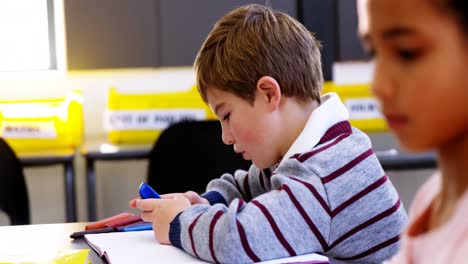 Schoolboy-using-mobile-phone-in-classroom