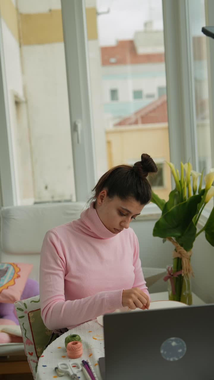 Giovane donna concentrata su un progetto creativo a casa