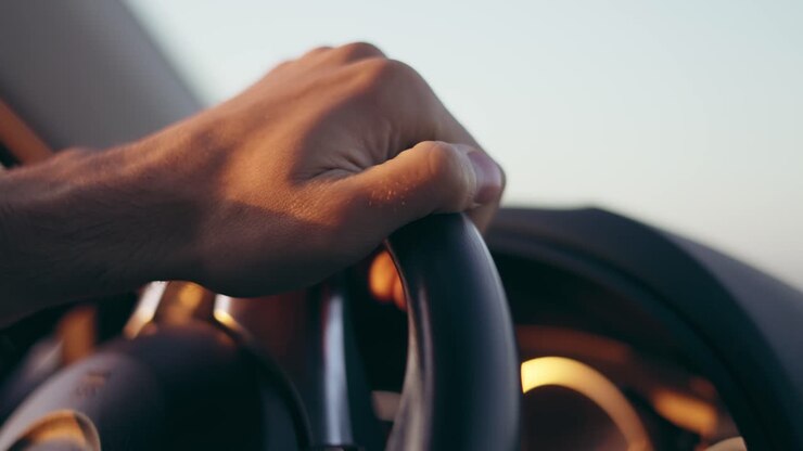 Main masculine tournant le volant.