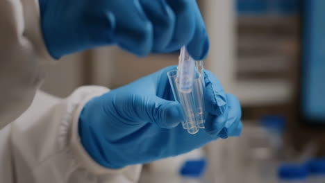 scientist in gloves handling test tubes in a laboratory