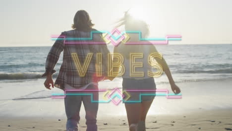 animation of yellow neon text vibes, over holiday couple holding hands walking on sunny beach