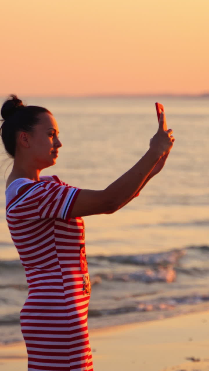 Woman Taking a Selfie at Sunset on the Beach