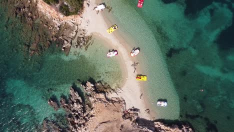 Botes-De-Pedales-Y-Una-Pequeña-Playa-De-Arena-Blanca-En-Las-Islas-Ksamil,-Albania---Antena-Arriba-Hacia-Abajo-Ascendente