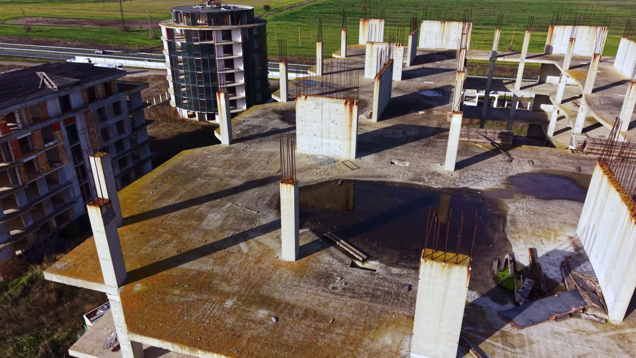 Lo scheletro in cemento di un futuro edificio si staglia contro un cielo azzurro, mostrando la bellezza grezza dello sviluppo urbano durante le ore diurne