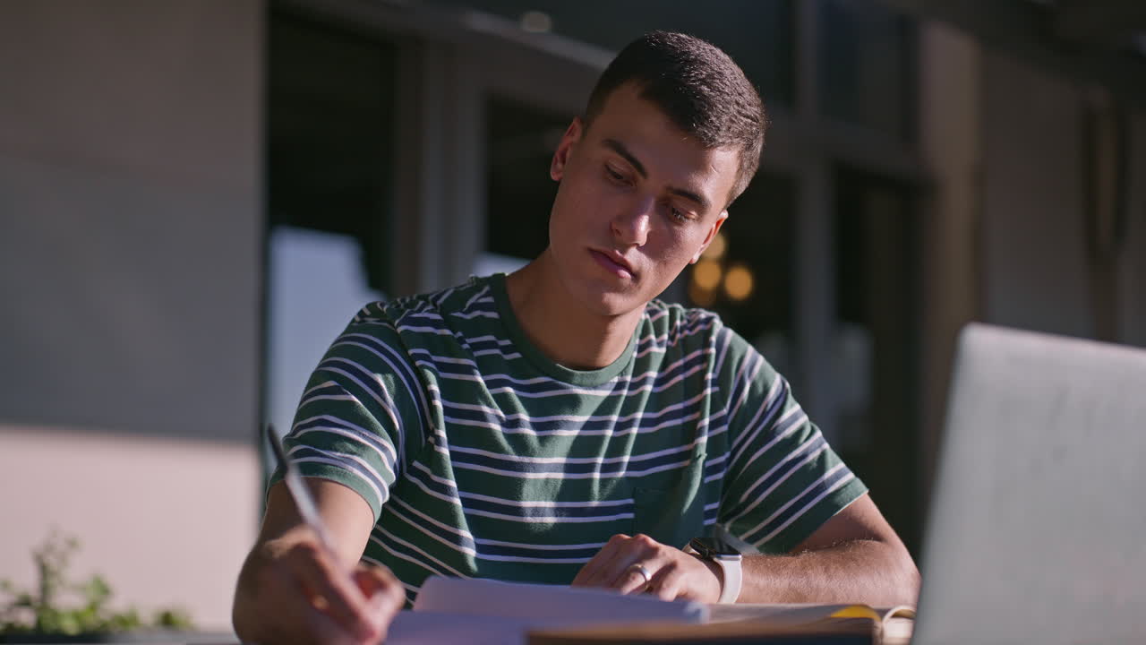 Man studying outdoors with laptop