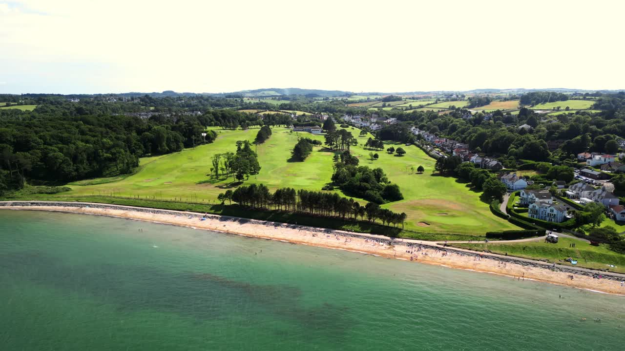 Wide reversing 4K 30FPS aerial video of Helen's Bay Beach in County Down, Northern Ireland in the UK. Edited with Rec709 color