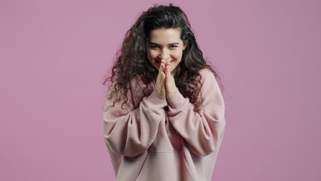 woman in pink hoodie with hands together