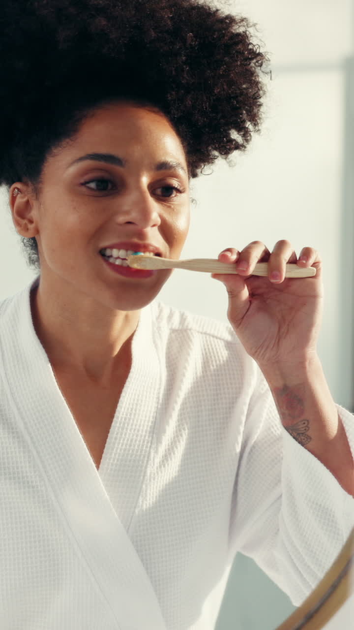 Donna che si lava i denti in bagno