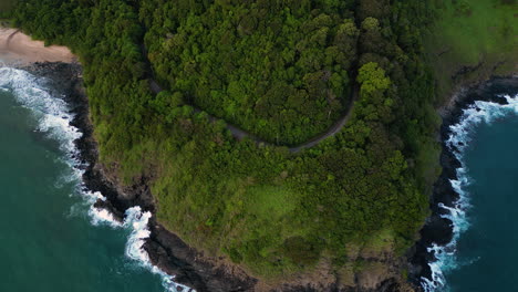 drone fly above koh lanta island in krabi province thailand, jungle little road path and waves crashing on solitary tropical white sand beaches in south east asia paradise