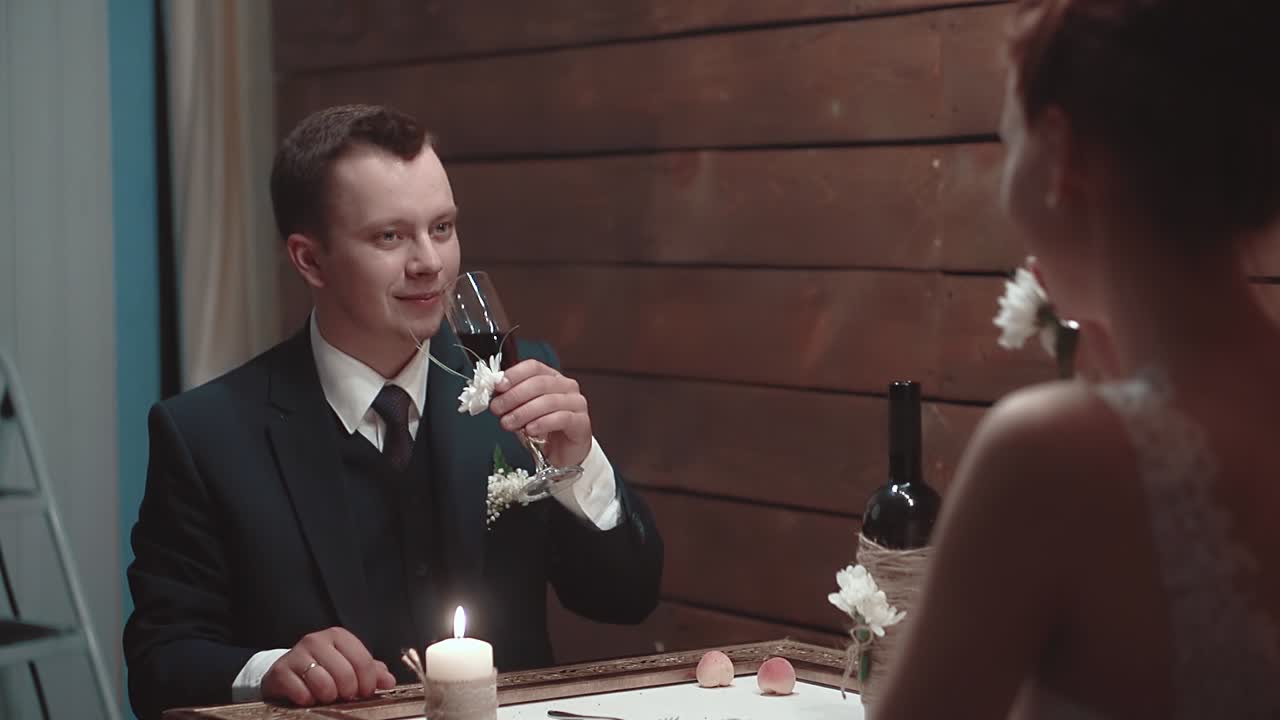젊은 남자와 그의 아름다운 소녀는 레스토랑에서 저녁 식사 중에 와인을 마시고 느린 동작 1